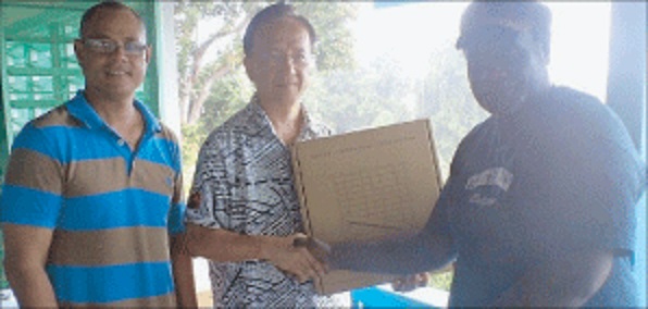 Pictured is Trade Commissioner Daniel Hu presenting the solar kits to Mr Beani, while North Bougainville MP Lauta Atoi looks on. Pictured is Trade Commissioner Daniel Hu presenting the solar kits to Mr Beani, while North Bougainville MP Lauta Atoi looks on.